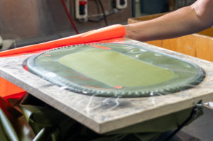 Employee preparing to RF seal a green army bag
